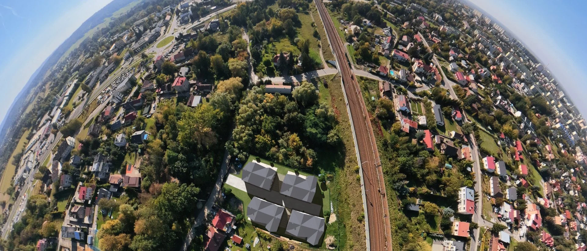 Osiedle po wybudowaniu z lotu ptaka — makieta budynków wstawiona w zdjęcie z drona, wizualizacja poglądowa. Dookoła tory, domy jednorodzinne, w tle Tarnów.